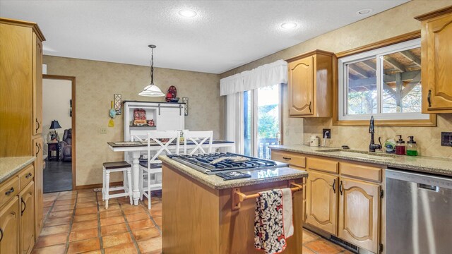3166 W Seminole St, Springfield, MO 65807 - kitchen featuring appliances with stainless steel finishes, a sink, a textured ceiling, a kitchen island, and hanging light fixtures
