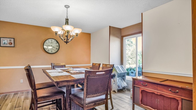 3166 W Seminole St, Springfield, MO 65807 - dining area featuring a chandelier, light wood finished floors, a textured ceiling, and baseboards