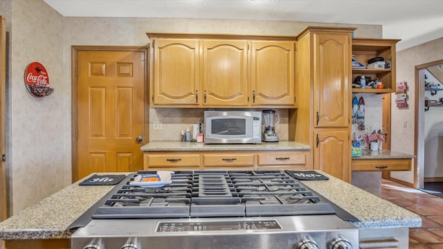 3166 W Seminole St, Springfield, MO 65807 - kitchen featuring stainless steel microwave, tile patterned floors, open shelves, and stove