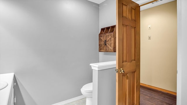 3166 W Seminole St, Springfield, MO 65807 - bathroom with vanity, toilet, baseboards, and wood finished floors