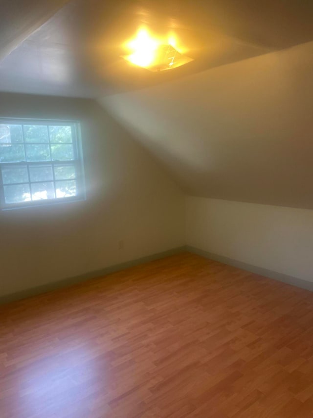 bonus room with vaulted ceiling and hardwood / wood-style floors