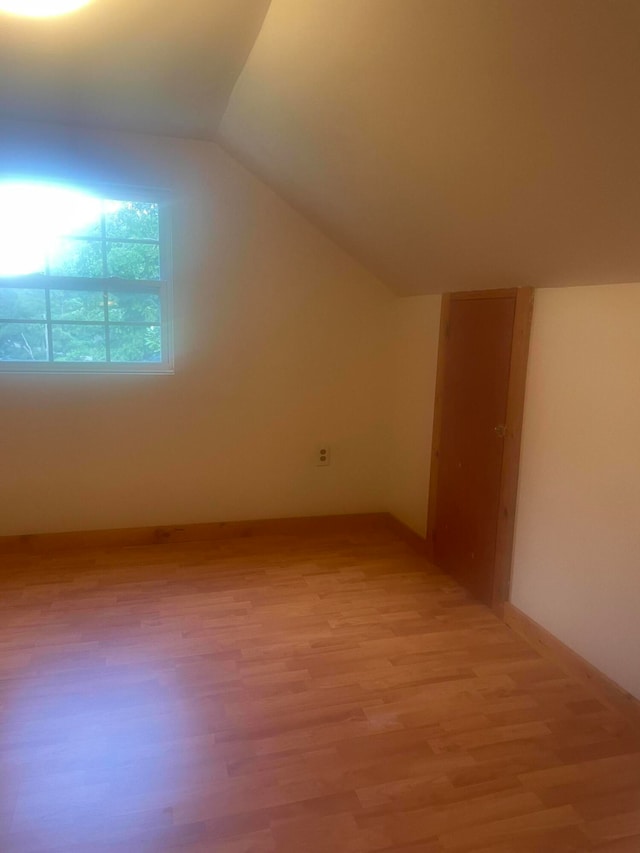 bonus room featuring vaulted ceiling and light hardwood / wood-style floors