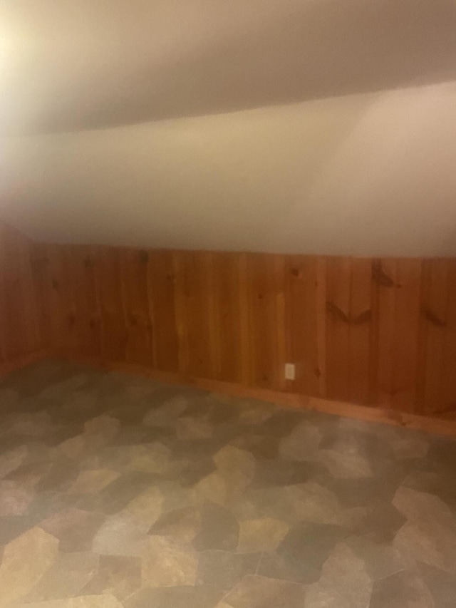 bonus room featuring wood walls