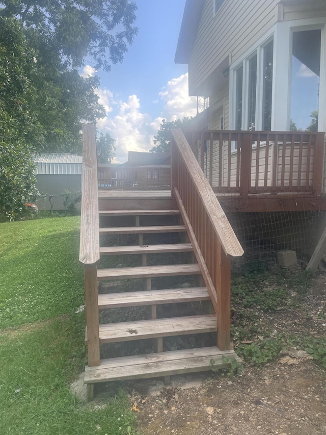 wooden deck featuring a lawn and stairway