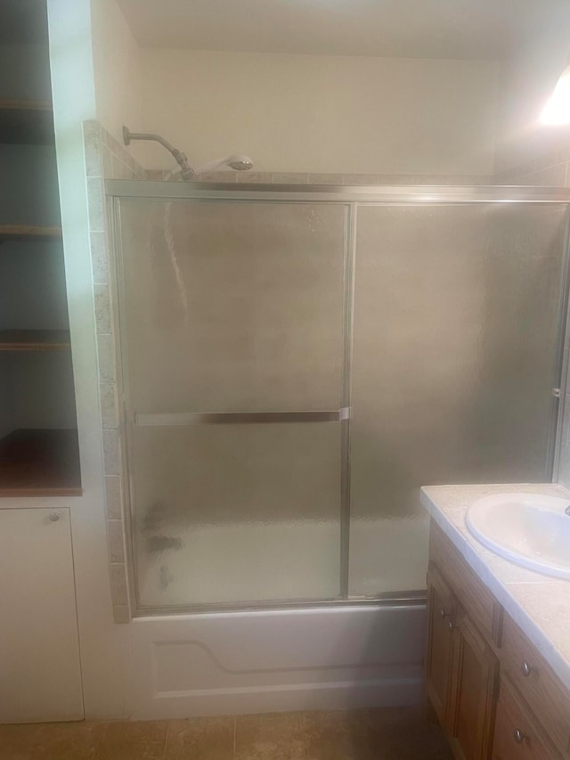 bathroom featuring tile patterned floors, shower / bath combination with glass door, and vanity