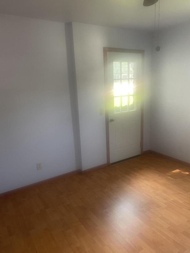 empty room featuring baseboards and light wood-style floors