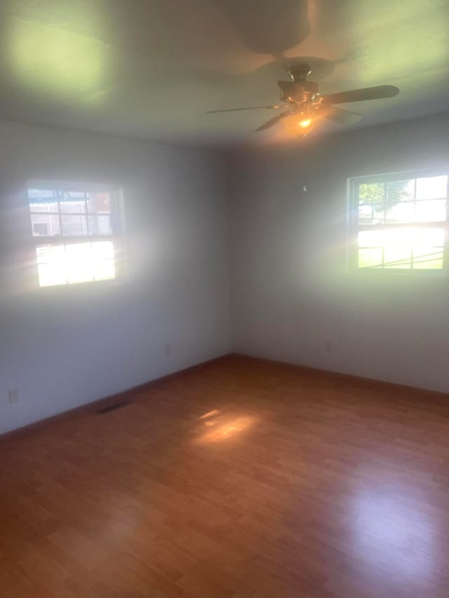 empty room with ceiling fan and wood-type flooring