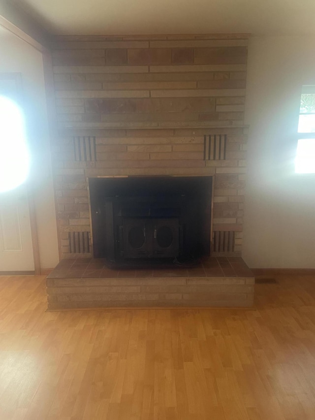 interior details with wood finished floors and a fireplace with raised hearth