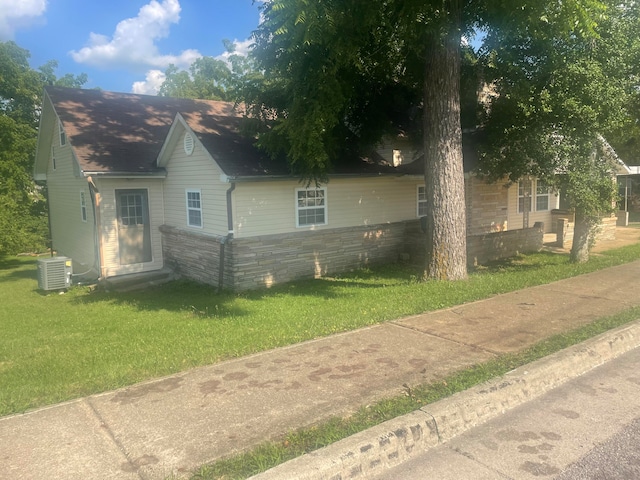 view of property exterior featuring a yard and central AC