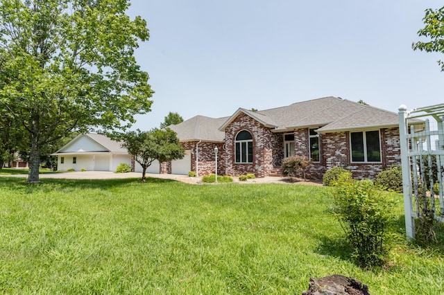 ranch-style home with a garage, driveway, brick siding, and a front yard