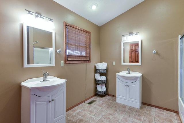 bathroom featuring bath / shower combo with glass door, vaulted ceiling, and vanity