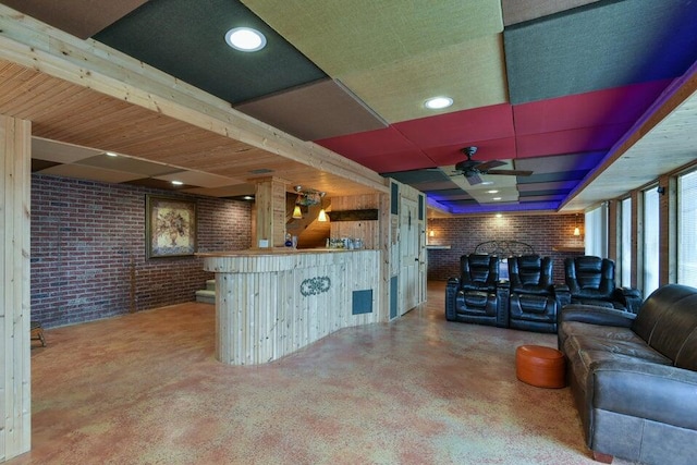 living room with ceiling fan, brick wall, and bar area