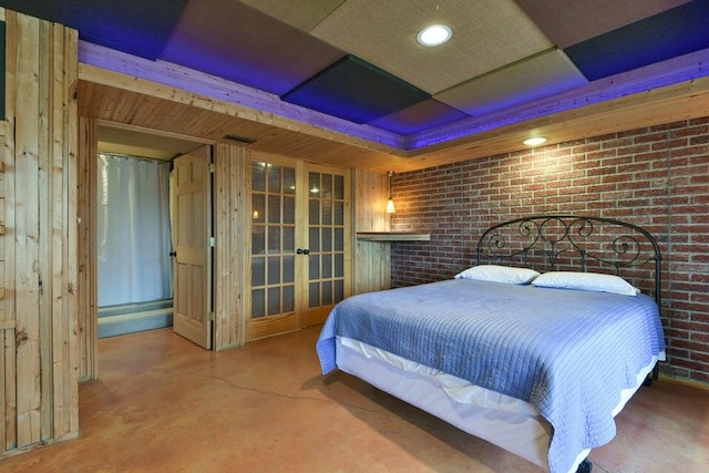 bedroom with brick wall, wooden walls, and concrete flooring