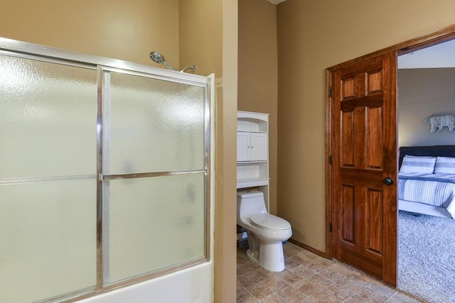 bathroom featuring combined bath / shower with glass door and toilet