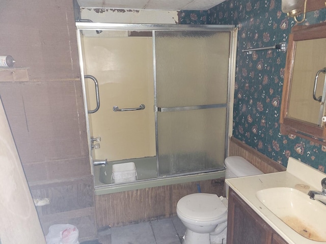 full bathroom featuring tile patterned floors, toilet, bath / shower combo with glass door, and vanity