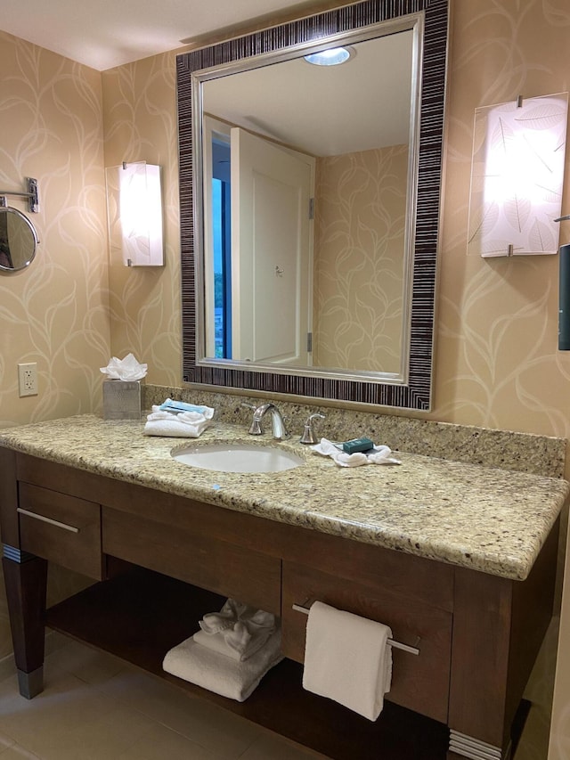 bathroom featuring vanity, tile patterned floors, and wallpapered walls