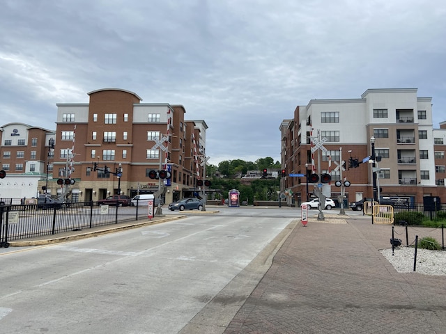 view of street featuring street lights, curbs, sidewalks, and traffic lights