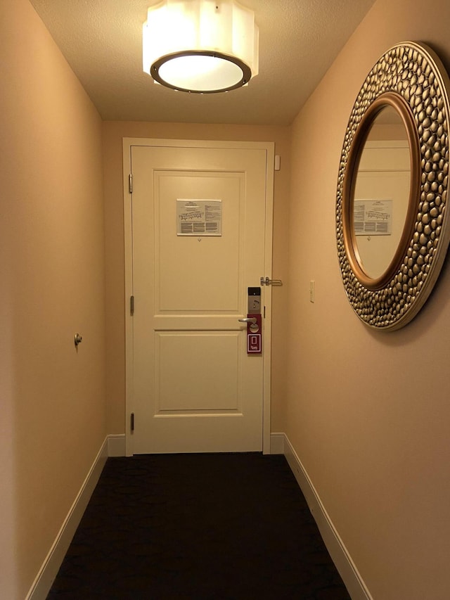 entryway with a textured ceiling and baseboards