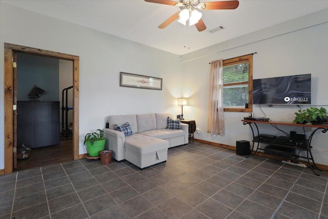 living room featuring baseboards, a ceiling fan, and visible vents