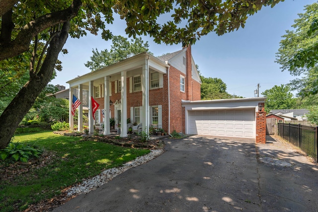 neoclassical home featuring covered porch, a garage, and a front lawn