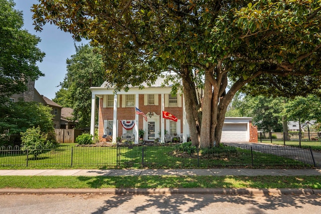 greek revival house with a garage and a front lawn