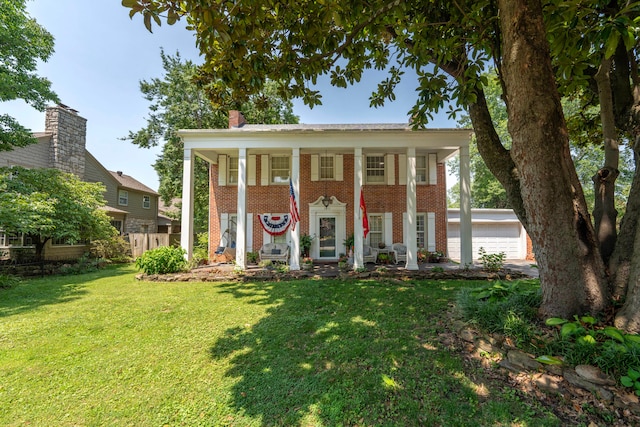 greek revival inspired property featuring an outbuilding, a front yard, and a garage