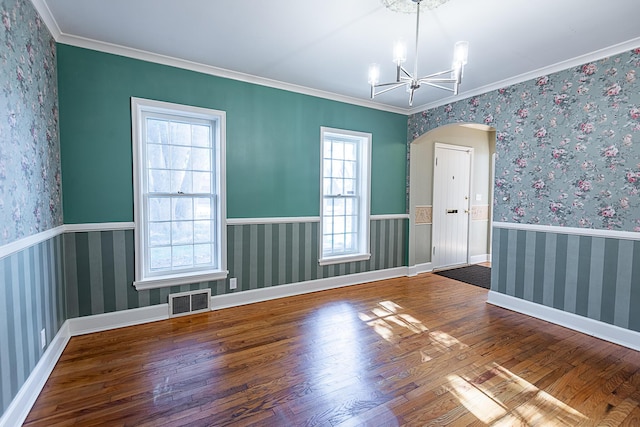 1011 E University St, Springfield, MO 65807 - unfurnished room with wood finished floors, a chandelier, arched walkways, ornamental molding, and a wainscoted wall