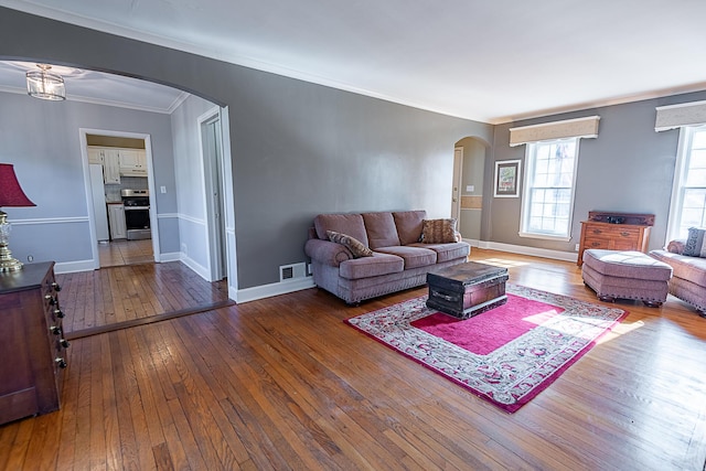 1011 E University St, Springfield, MO 65807 - living room featuring arched walkways, wood-type flooring, and ornamental molding