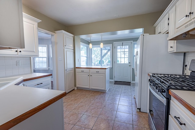 1011 E University St, Springfield, MO 65807 - kitchen with gas range, decorative backsplash, plenty of natural light, and white cabinets
