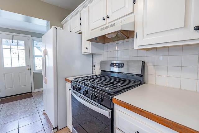 1011 E University St, Springfield, MO 65807 - kitchen with gas stove, under cabinet range hood, decorative backsplash, white cabinets, and light countertops