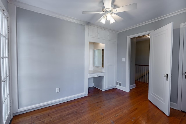 1011 E University St, Springfield, MO 65807 - unfurnished room with wood finished floors, crown molding, a ceiling fan, built in desk, and plenty of natural light