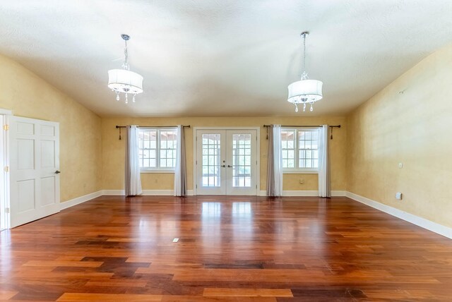 interior space with french doors, plenty of natural light, dark hardwood / wood-style floors, and a notable chandelier