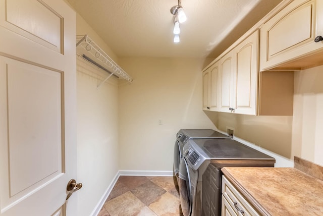 laundry area with separate washer and dryer and cabinets