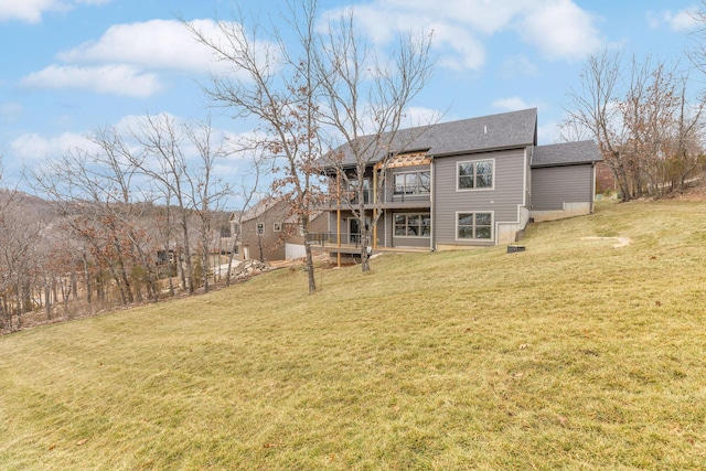 rear view of house featuring a deck and a yard