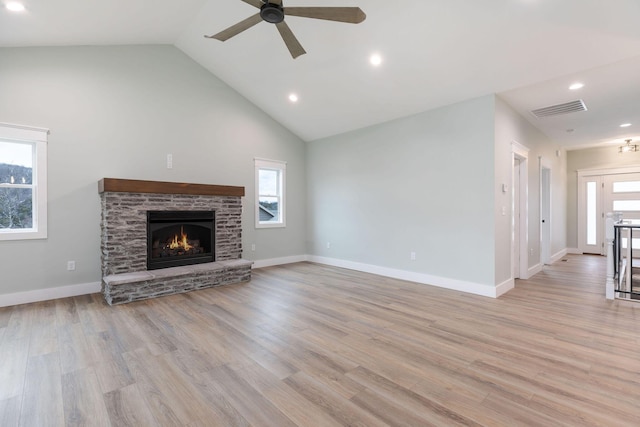 unfurnished living room with light wood-type flooring, ceiling fan, a fireplace, and high vaulted ceiling