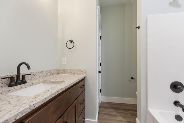 bathroom with tub / shower combination, vanity, and wood-type flooring