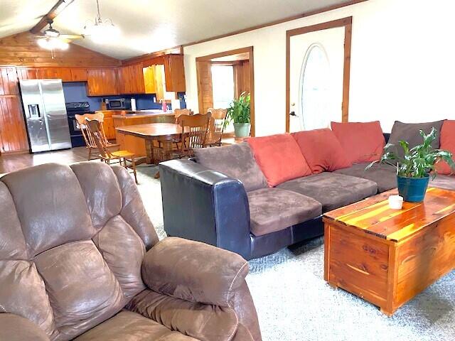 living room featuring ceiling fan and vaulted ceiling