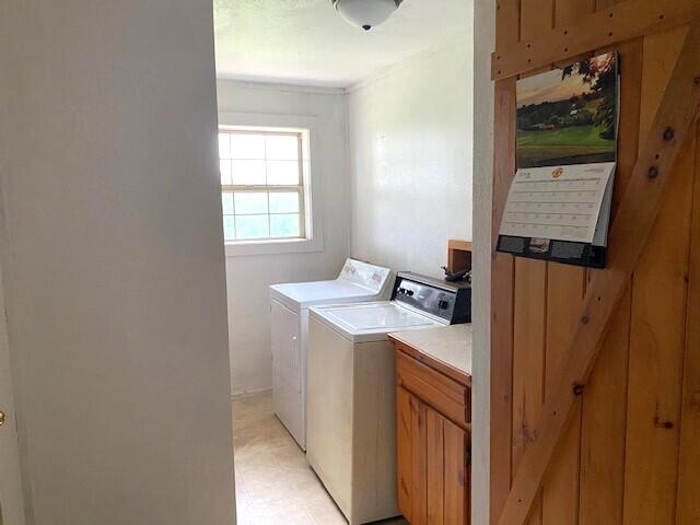 washroom featuring washing machine and clothes dryer and cabinets