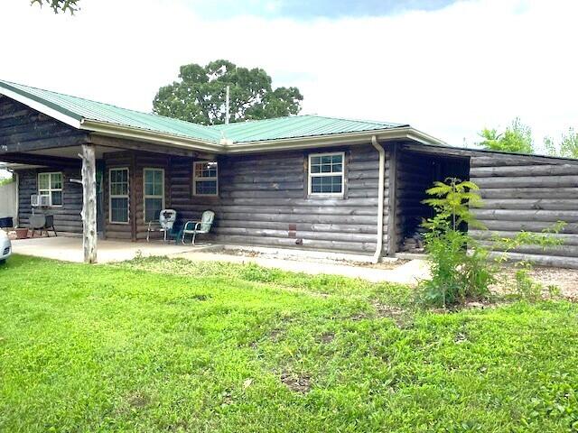 back of house featuring a patio area and a lawn