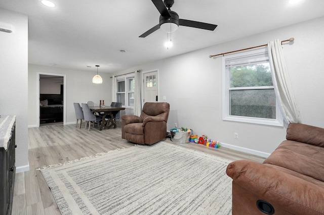 living room with ceiling fan and light wood-type flooring