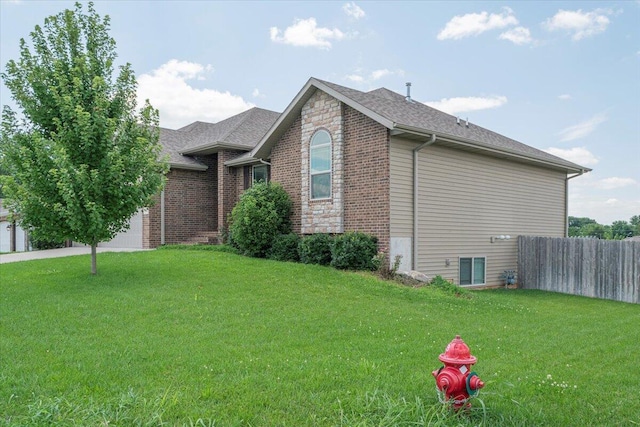 1641 N Pinnacle Ave, Nixa, MO 65714 - view of home's exterior with brick siding, a yard, a shingled roof, and fence