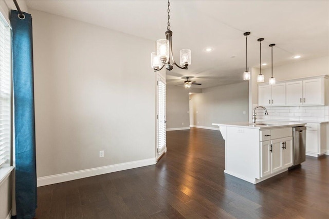 kitchen featuring a center island with sink, hanging light fixtures, white cabinetry, and dark hardwood / wood-style flooring