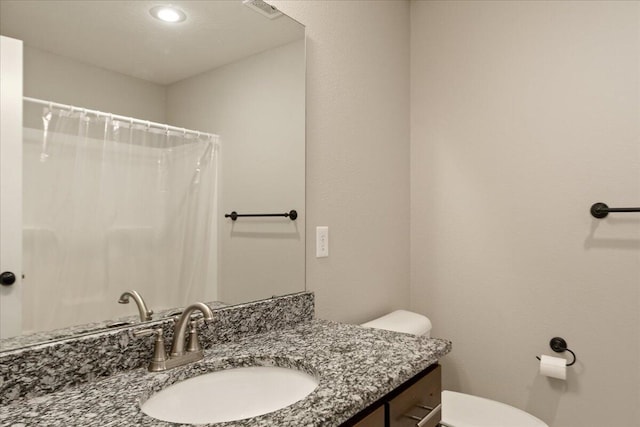 bathroom with a shower with shower curtain, vanity, and toilet