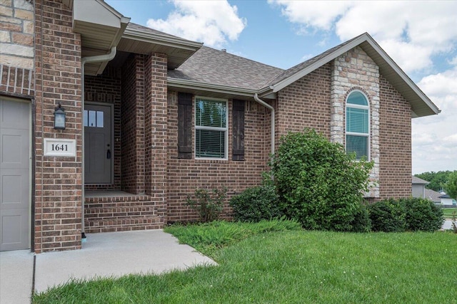 1641 N Pinnacle Ave, Nixa, MO 65714 - property entrance with brick siding, a yard, and roof with shingles