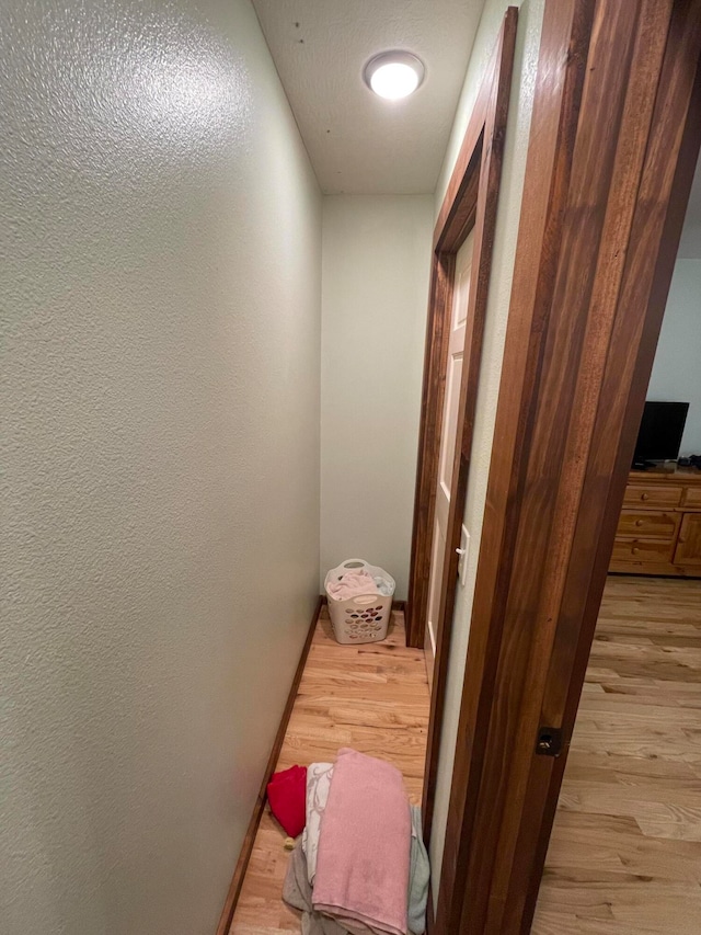 hallway with light hardwood / wood-style floors