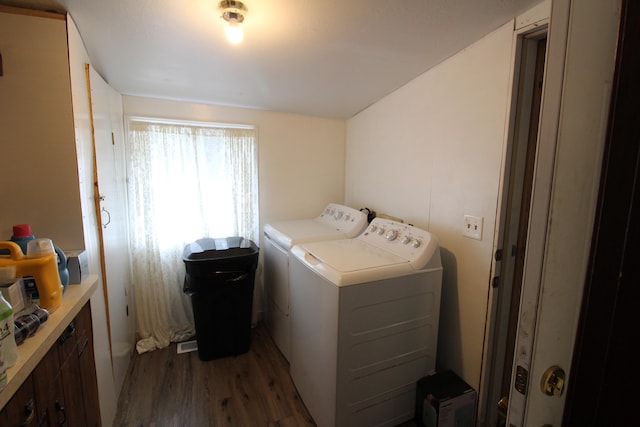 clothes washing area with washing machine and clothes dryer and dark hardwood / wood-style flooring