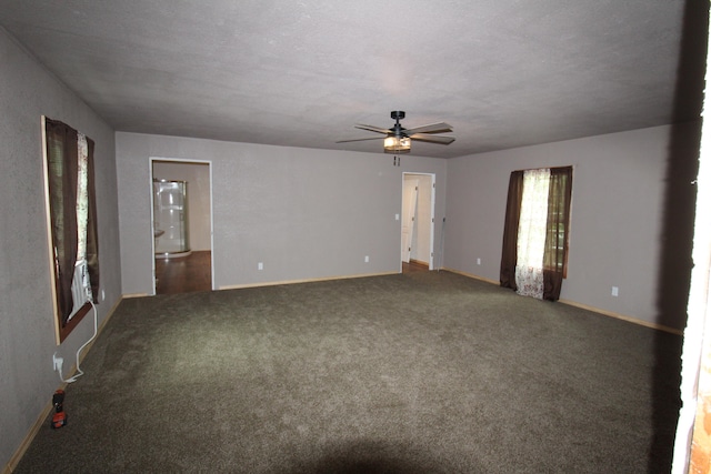 unfurnished room featuring dark colored carpet, a textured ceiling, and ceiling fan