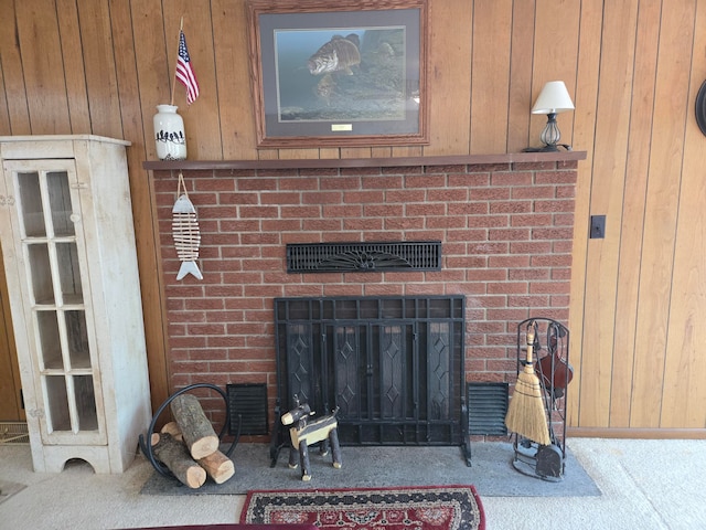 carpeted living room featuring a fireplace and wood walls