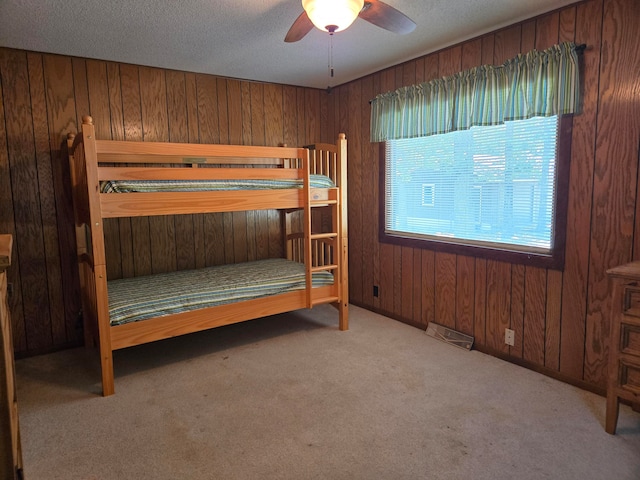 unfurnished bedroom with ceiling fan, light colored carpet, and wooden walls