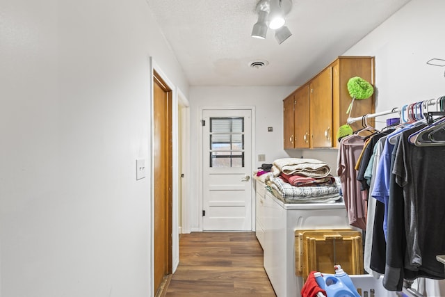 washroom featuring independent washer and dryer, dark hardwood / wood-style flooring, and a textured ceiling